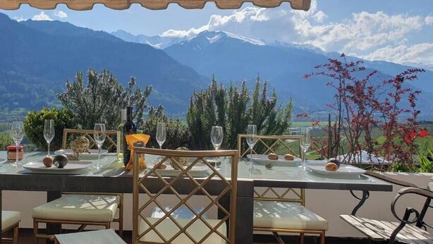 A dining table set outdoors with a mountain view. - Grand Maisonette-Attica, Jenins, Top of Heidiland (Jenins)