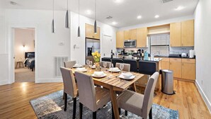 A modern kitchen with wooden cabinets, a stainless steel refrigerator, and a microwave. - Houston Getaway by Downtown | Pool Table | Pets (Houston)