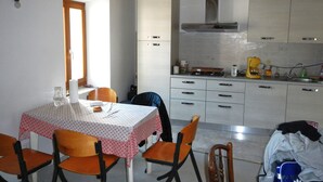 A kitchen with a dining table, chairs, and cabinets.