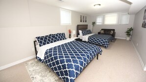 Quarto com duas camas, uma janela grande e um ventilador de teto.