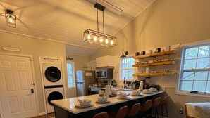 A kitchen with a central island, wooden flooring, and built-in appliances.