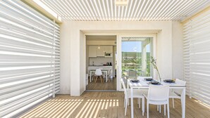 Et moderne køkken med hvide skabe og et spiseområde med et bord dækket til to personer.