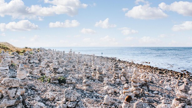 A rocky beach with stacks of stones and a clear view of the sea. - Beach front home in Nykøbing Sj with WiFi (Nykøbing Sj)