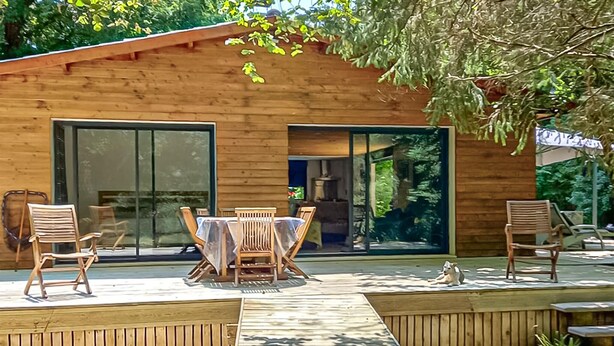 A wooden cabin with a patio, a dining table, and chairs. - Cozy home in Pradines with house sea view (Pradines)