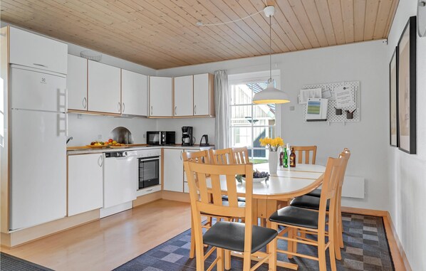 Enjoy meals in the kitchen with oven, microwave, and coffee maker, surrounded by a dining table and comfortable chairs.