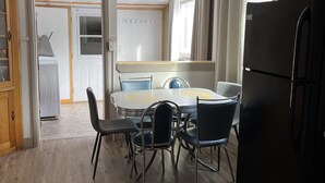 A kitchen with a dining table, chairs, a ceiling fan, a refrigerator, and a window. - Spacious Historical Home in Downtown Philipsburg (Philipsburg)