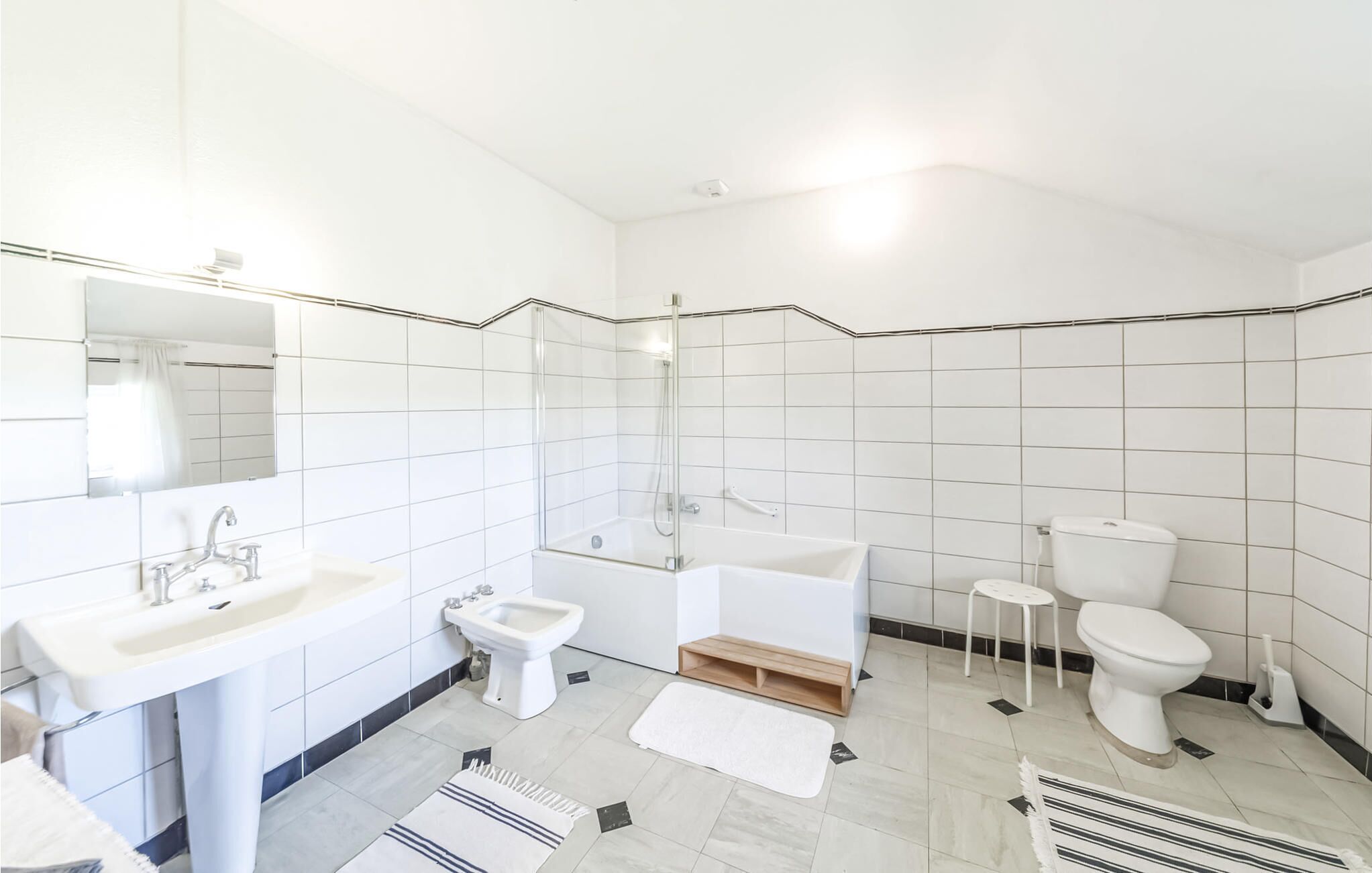 Un bany modern amb rentatge, bidet, banyera i vàter.