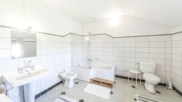 Un bany modern amb rentatge, bidet, banyera i vàter.