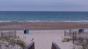 Ein Strand mit Holzzaun und Mülleimern.
