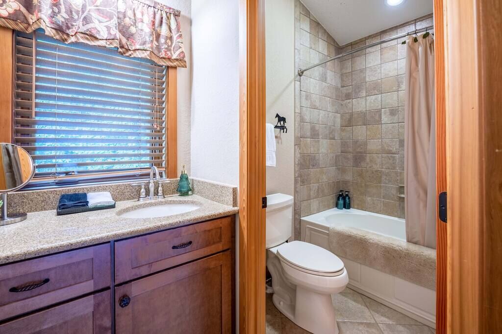 Ein Badezimmer mit Waschbecken, Spiegel und Toilette.