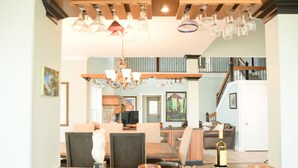 A dining area with a wooden table, chairs, and a chandelier. There is a staircase leading to an upper level. - Beautiful Villa with Pool & Scenic Views in foothills close to Sequoia's (Exeter)