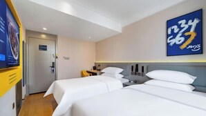 A hotel room with two beds, a television, a desk, and a painting on the wall.