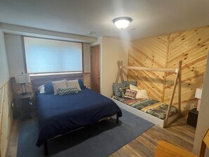 Une chambre à coucher avec un lit, une fenêtre, un mur en bois et un luminaire au plafond.