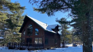 A wooden cabin with a steep roof, large windows, and a porch. - Lake cabin on Holcombe flowage. Loft views, fire pit, and nearby hiking. (Holcombe)