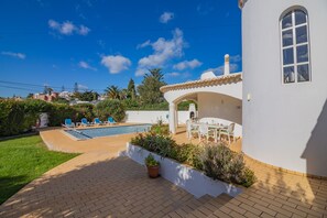 Une maison avec une piscine, un espace extérieur aménagé et un jardin.