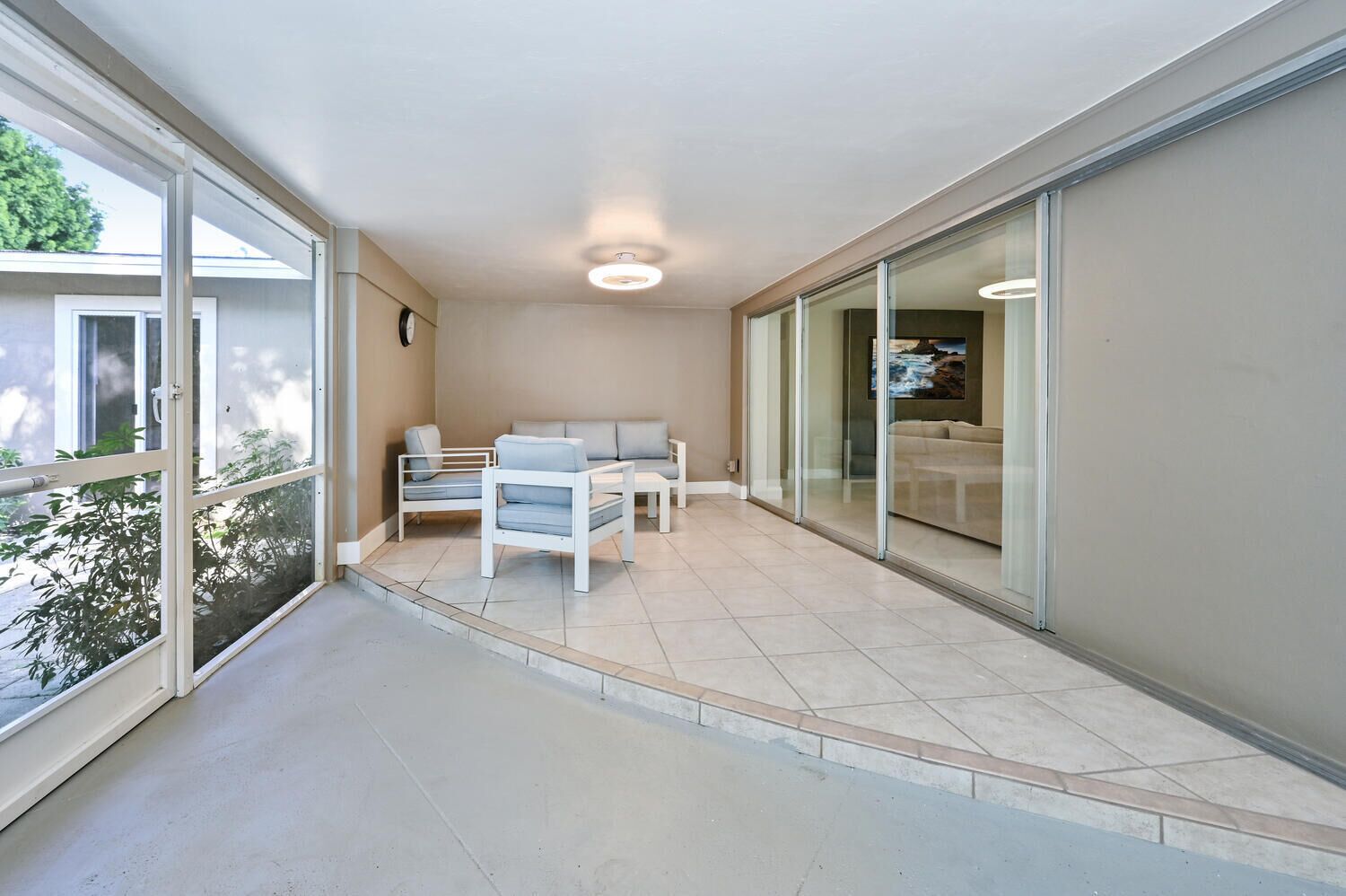 A balcony with a sofa, two chairs, and a small table.