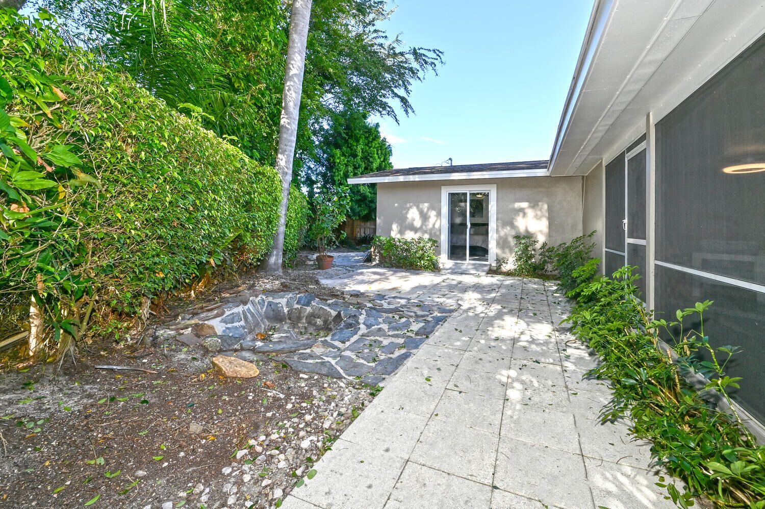 A modern building with a stone pathway leading to a glass door entrance.