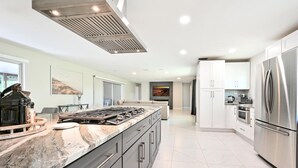 A modern kitchen with a large island, stainless steel appliances, and a sleek design.