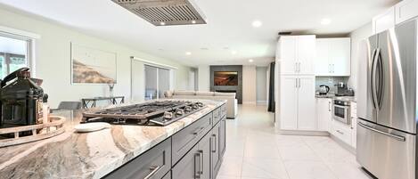 A modern kitchen with a large island, stainless steel appliances, and a sleek design.
