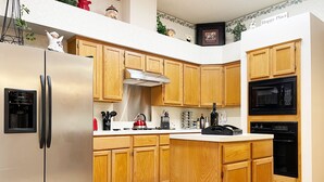 Una cucina moderna con mobili in legno, elettrodomestici in acciaio inossidabile e un'isola centrale.