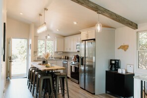 Enjoy cooking in this well-equipped kitchen with a central island, bar stools, and stainless steel appliances.