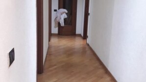 A hallway with wooden flooring, white walls, and wooden doors. - Modern and cosy apartment in Genoa, Italy (Genova)