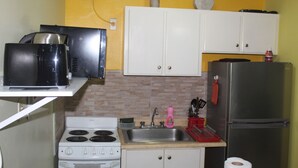 A compact kitchen with a stove, sink, and refrigerator.