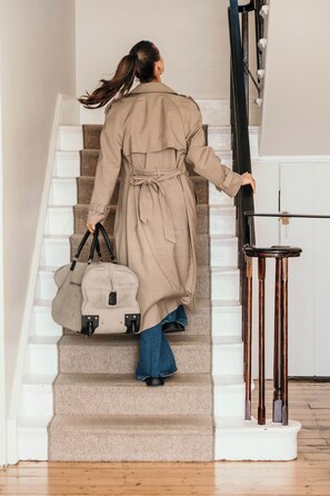 A person descending a staircase with a beige coat and a handbag. - The Oak & Anchor Hotel (Port Fairy)