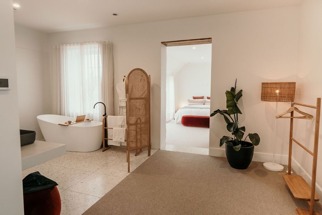 Een moderne badkamer met een vrijstaand bad, een douchegedeelte en een grote kamerplant.