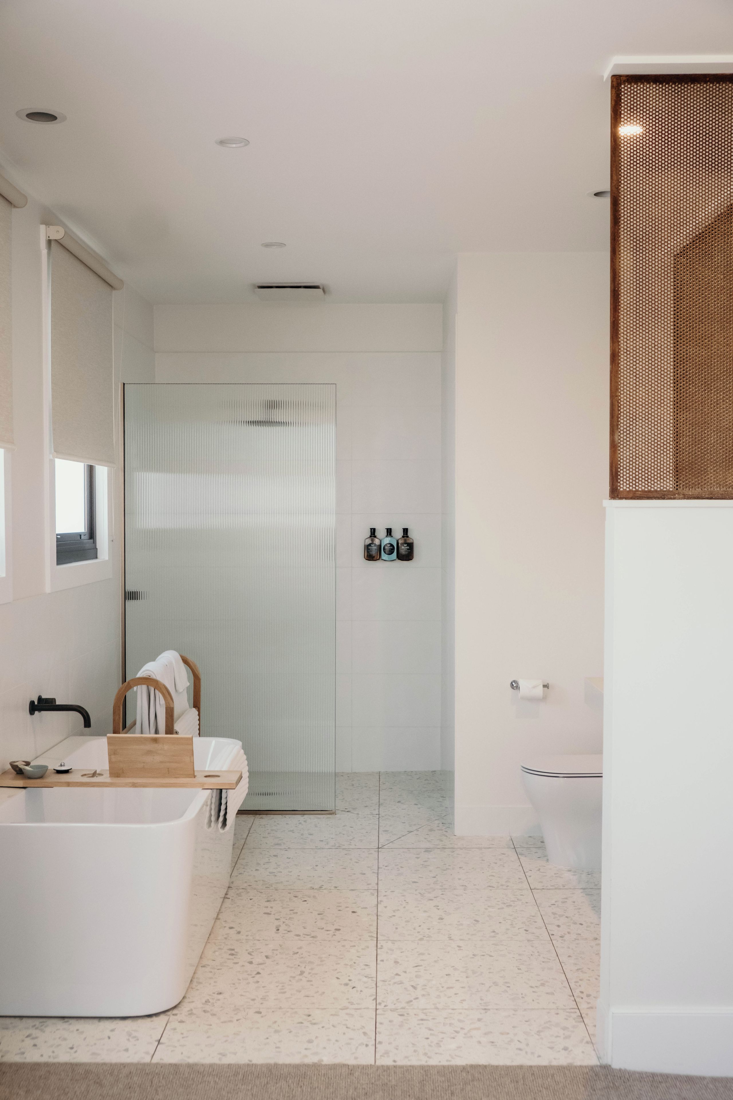 A modern bathroom with a freestanding bathtub, a glass shower enclosure, and a toilet.