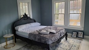 Ein Schlafzimmer mit Bett, Fenster und einem kleinen Tisch.