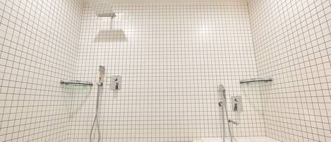 Un baño con paredes de azulejos blancos y una bañera blanca.