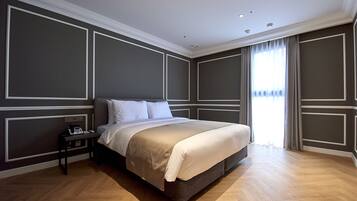 Une chambre d’hôtel moderne avec un grand lit, une table de chevet avec un téléphone et une fenêtre avec des rideaux.