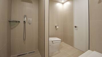 A modern bathroom with a glass shower enclosure, a toilet, and a sink.