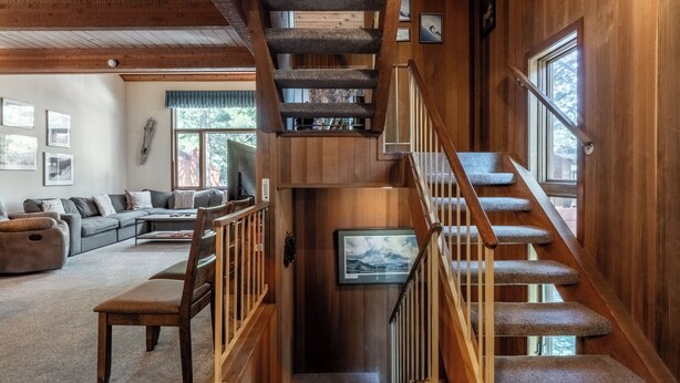 A wooden staircase with a handrail, carpeted steps, and a view of a living room with a sofa and a television. - Spacious Winterset 26 2 Bedrm Plus Loft 3 Full Bathrm Townhome Sleeps 8 Steps to Free Town Shuttle (Mammoth Lakes)