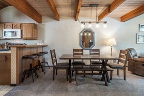 Eine Küche mit Holzausstattung, einer Mikrowelle und einer Bar mit Sitzgelegenheiten.