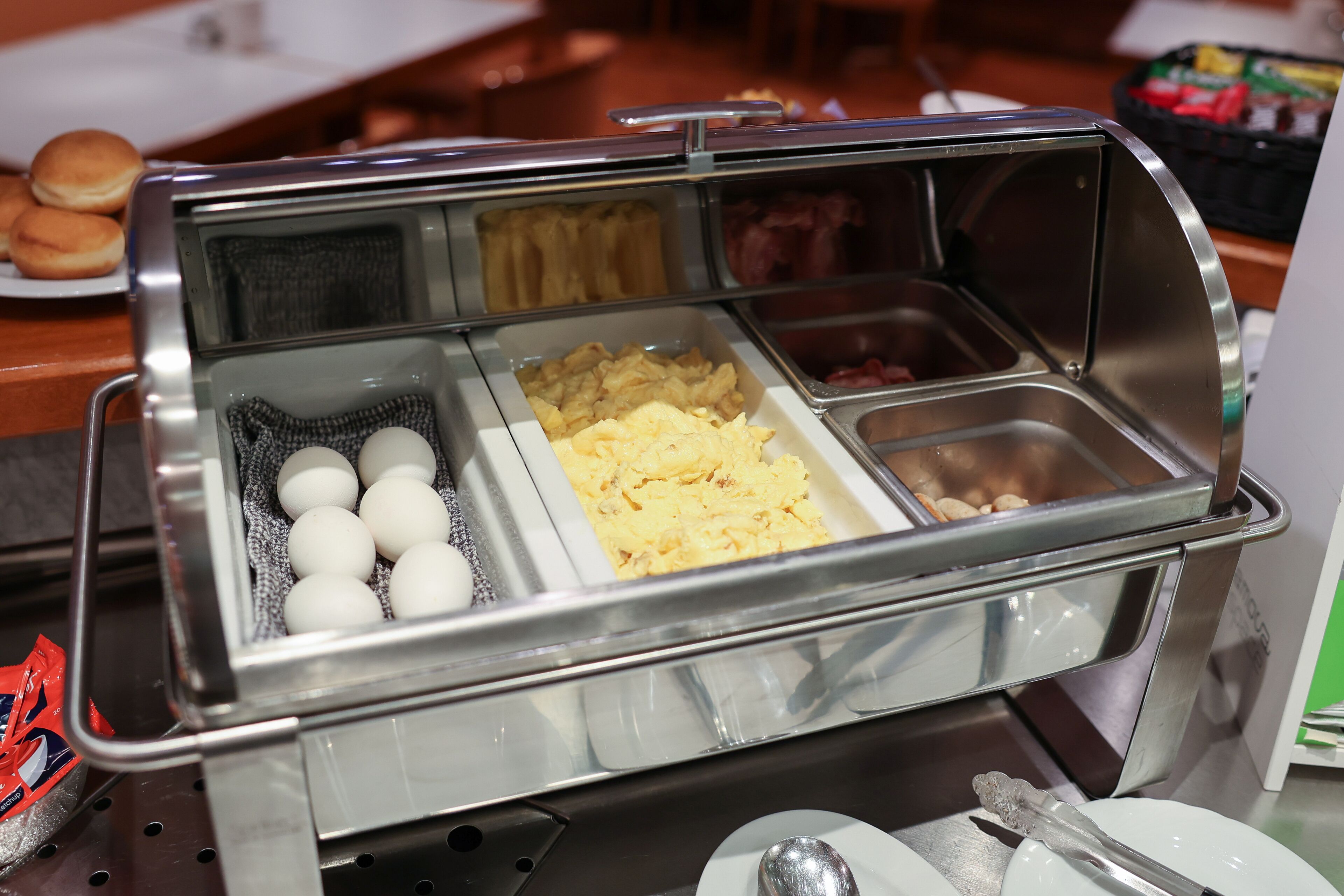 A buffet with various food options including eggs, scrambled eggs, and other dishes.