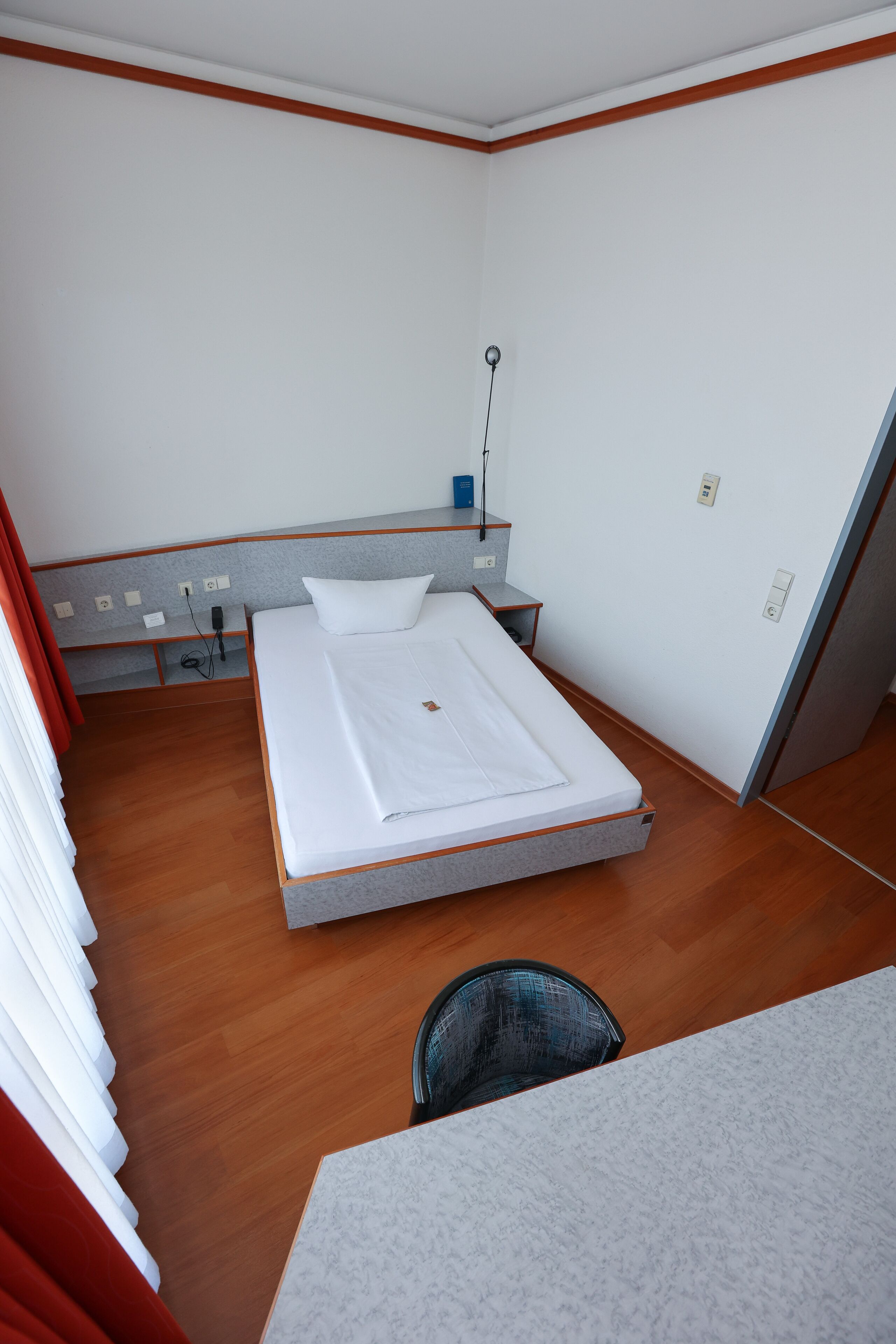 Una habitación de hotel con una cama individual, un escritorio y una silla.