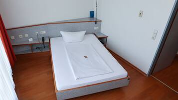 Una habitación de hotel con una cama individual, un escritorio y una silla.