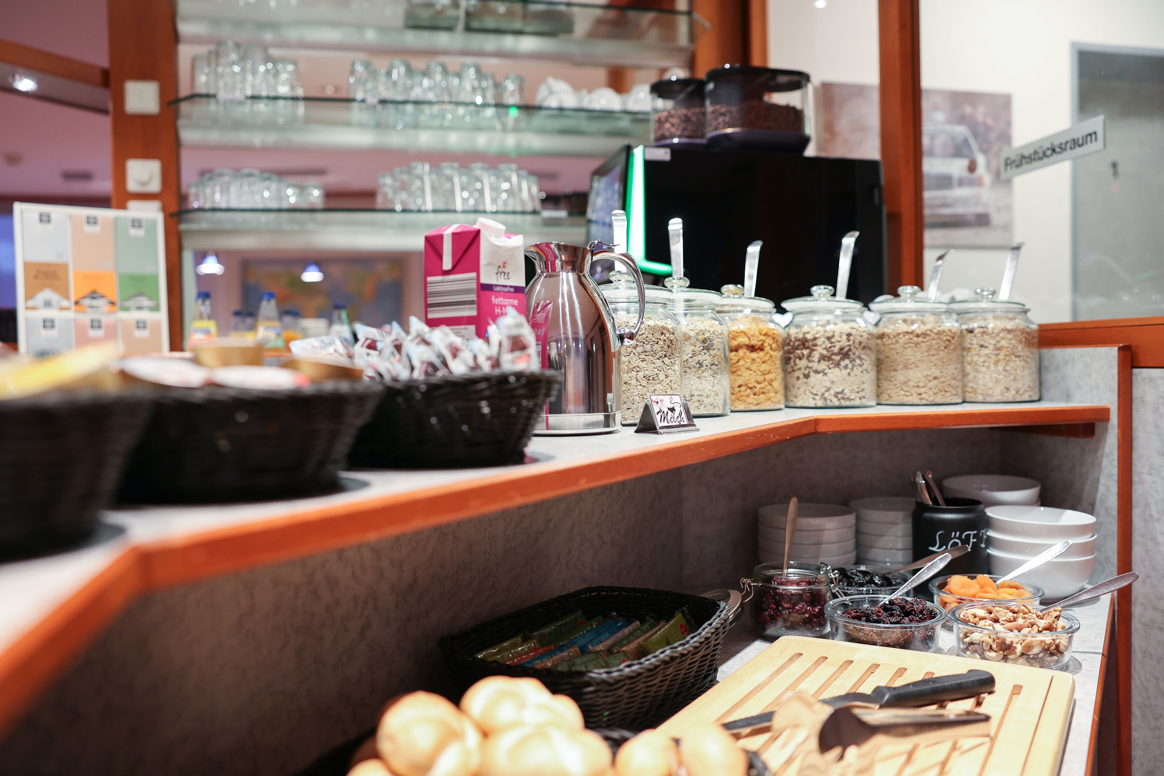 A breakfast buffet with various food items, including fruits, cereals, and condiments.