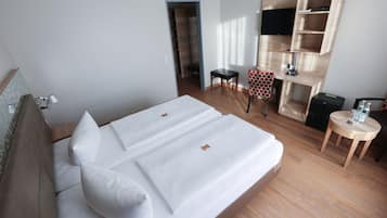 Una habitación de hotel con cama, escritorio, silla y televisión.