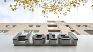 A hotel sign with the word "Hotel" in metallic letters on a white surface. - Hotel Blaubeurer Tor (Ulm)