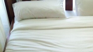 A bed with white bedding and a wooden headboard. - Lalwa Safari Lodge (Kabarnet)