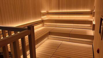Eine Sauna mit Holzbänken und leicht abfallendem Boden.
