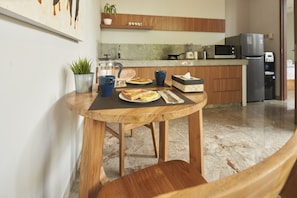 Enjoy meals together at the dining table for two, set against a beautiful wall art.