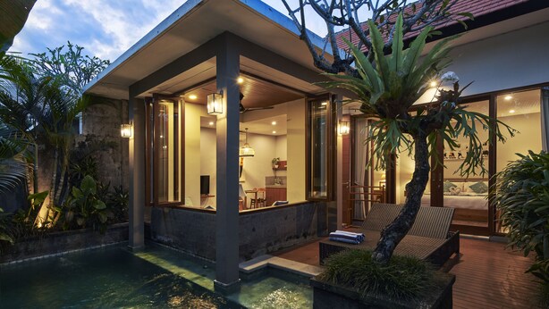 A modern house with a covered outdoor area, a pool, and a bedroom visible through large windows. - Prema Uja Villas (Ubud)