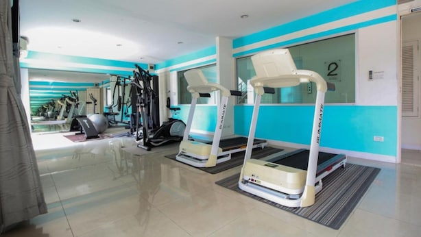 A gym with treadmills, elliptical machines, and weight equipment. - Meesook Residence (Nonthaburi)
