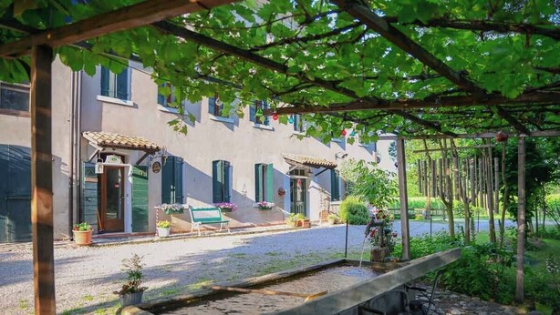 A building with a courtyard, a water feature, and a pergola with hanging decorations. - Antica "casa Cervade" Pica Venetian Farmhouse, Preserved Original From 1902 (Fontanelle)