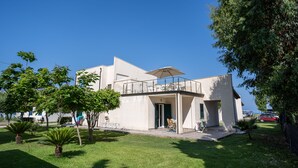 A modern two-story building with a balcony, surrounded by well-maintained lawns and trees. - Residence Emmesse Appartamenti Stardard (Zambrone)