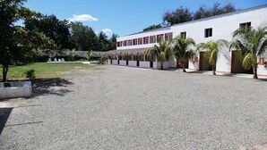 Un edificio con un largo corredor cubierto y un patio de grava.
